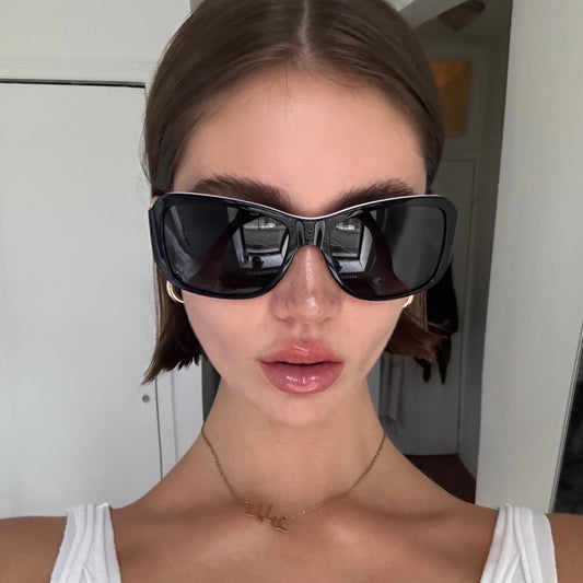 a model with freckles wearing black sunglasses