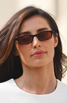 Woman wearing dark sunglasses with a blurred background
