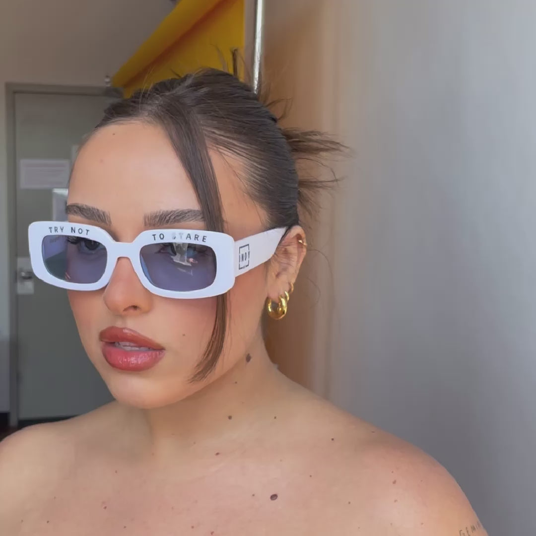 a model wearing white sunglasses in a photo studio