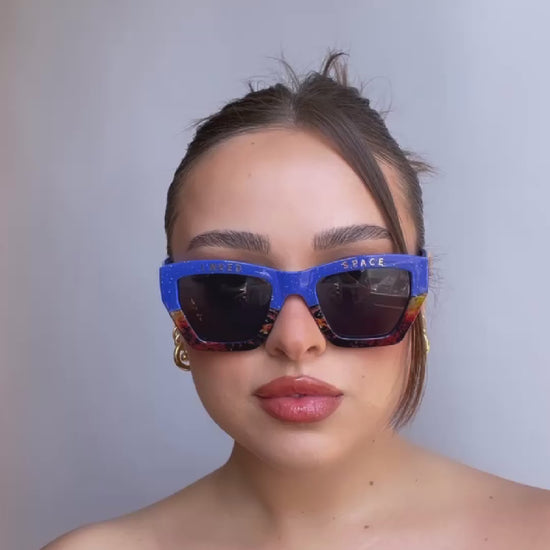 a girl wearing blue nasa inspired sunglasses