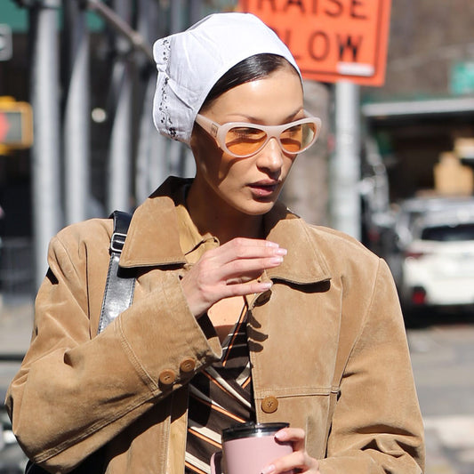 bella hadid wearing sunglasses and a white head scarf