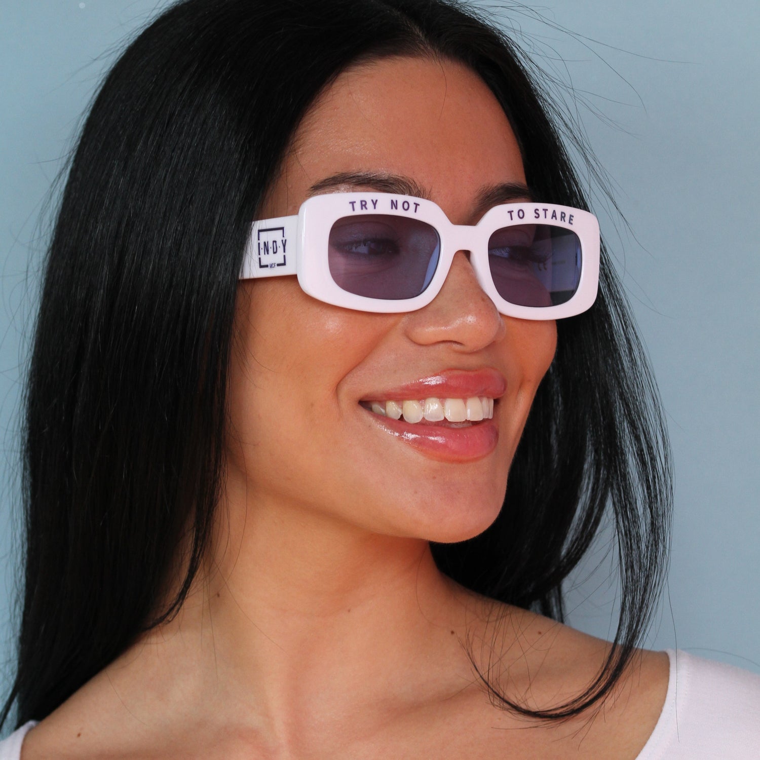 a girl smiling wearing white sunglasses