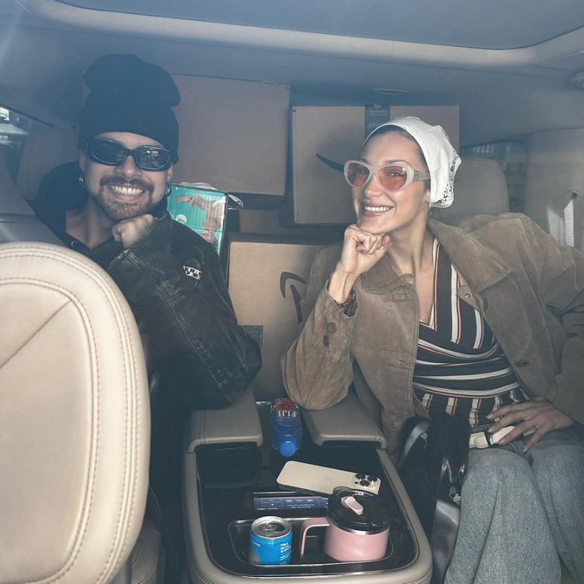 Bella Hadid in a car wearing sunglasses
